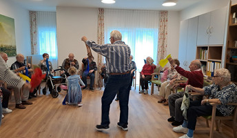 In der ProCurand Tagespflege Strausberg tanzen Senior*innen fröhlich mit den kleinen Besucher*innen durch den Raum – eine besondere Begegnung voller Lebensfreude.