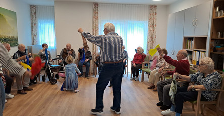 In der ProCurand Tagespflege Strausberg tanzen Senior*innen fröhlich mit den kleinen Besucher*innen durch den Raum – eine besondere Begegnung voller Lebensfreude.