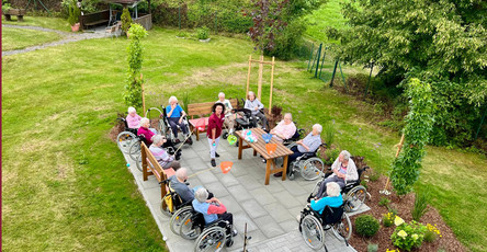 Vogelperspektive auf die Senior*innen beim Koordinationsspiel auf der neuen Terrasse im Garten des ProCurand Pflegestifts St. Ulrich in Lam.