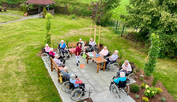 Vogelperspektive auf die Senior*innen beim Koordinationsspiel auf der neuen Terrasse im Garten des ProCurand Pflegestifts St. Ulrich in Lam.