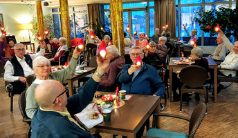  Bewohner*innen und Mieter*innen aus dem Service-Wohnen feiern gemeinsam im Café Havelterrasse der ProCurand Seniorenresidenz Havelpalais und erhalten leuchtende Wichtel.