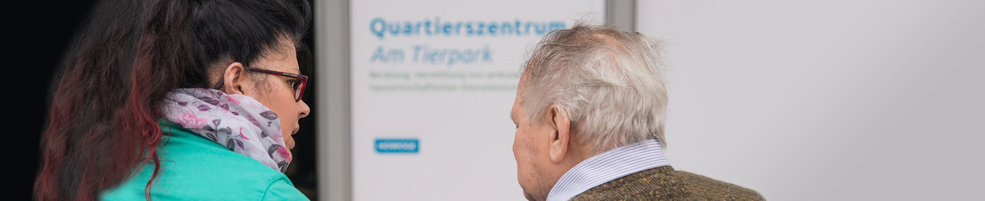 Mitarbeiterin berät Senior zu Pflegegrad