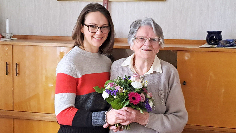 Stellvertretende Pflegedienstleitung Christin Teichmüller der ProCurand Ambulanten Pflege Wannsee gratuliert der Seniorin zum Geburtstag. 