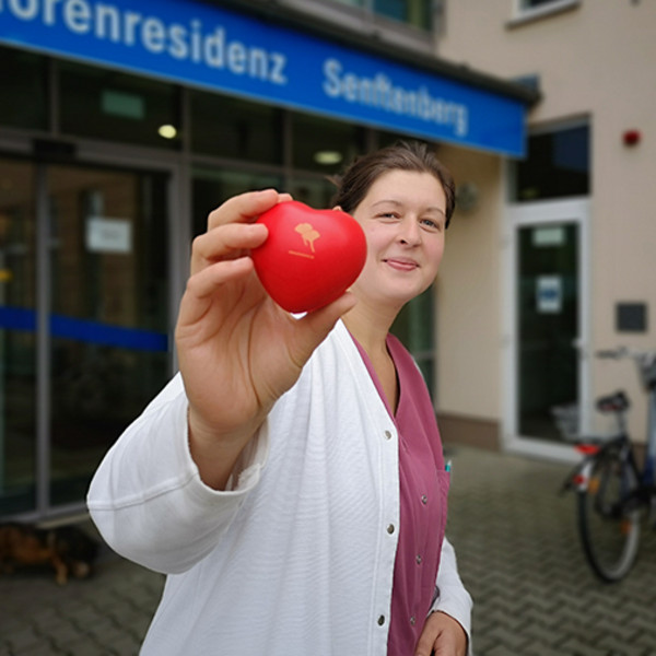 ProCurand Wohnbereichsleitung Pflegefachkraft Stephanie vor Seniorenresidenz Senftenberg mit ProCurand Herz