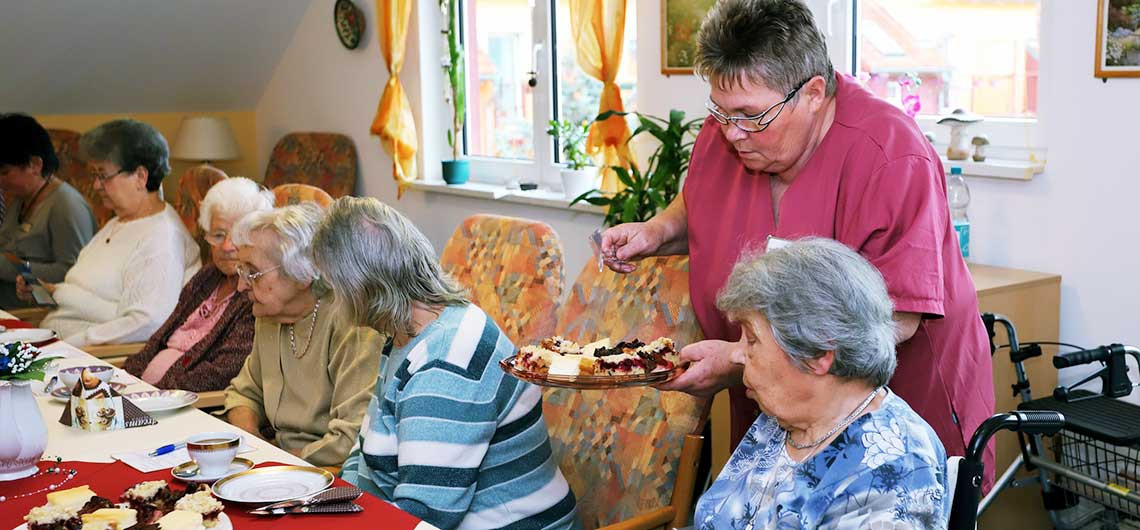 Bewohner der ProCurand Seniorenresidenz Eberswalde genießen in geselliger Runde ein Stück Kuchen
