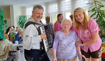 Musiker, Seniorin und Einrichtungsleitung beim Oktoberfest in der ProCurand Seniorenresidenz Am Straussee 