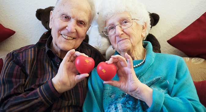 Zwei Senior*innen aus dem ProCurand Service-Wohnen mit ProCurand Herzen