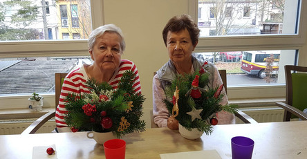 In der ProCurand Seniorenresidenz Bölschestraße sitzen zwei Bewohnerinnen an einem Tisch und gestalten gemeinsam weihnachtliche Adventsdekoration.