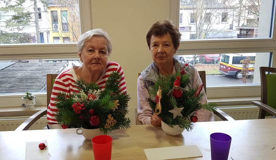 In der ProCurand Seniorenresidenz Bölschestraße sitzen zwei Bewohnerinnen an einem Tisch und gestalten gemeinsam weihnachtliche Adventsdekoration.
