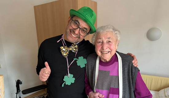 Neujahrsgruß im ProCurand Pflegestift Pfarrer Lukas in Cham: Bewohnerin mit Glücksboten Kleeblatt beim Rundgang durchs Haus.