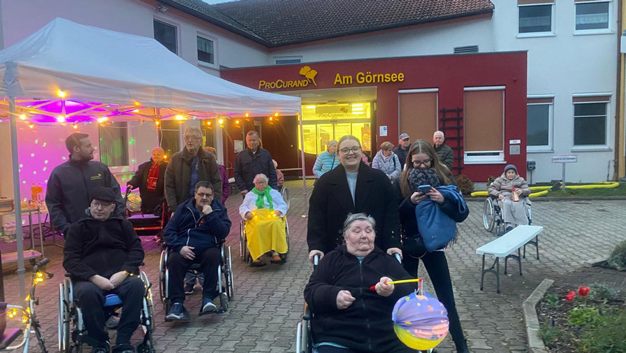 Vor der ProCurand Seniorenresidenz Am Görnsee versammeln sich Bewohner*innen und Angehörige mit Laternen und geschmückten Gehhilfen für den gemeinsamen Lampionumzug durch Kloster Lenin.