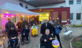 Vor der ProCurand Seniorenresidenz Am Görnsee versammeln sich Bewohner*innen und Angehörige mit Laternen und geschmückten Gehhilfen für den gemeinsamen Lampionumzug durch Kloster Lenin.