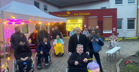 Vor der ProCurand Seniorenresidenz Am Görnsee versammeln sich Bewohner*innen und Angehörige mit Laternen und geschmückten Gehhilfen für den gemeinsamen Lampionumzug durch Kloster Lenin.