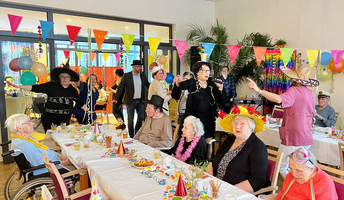 Die Senior*innen und Mitarbeiter*innen der ProCurand Seniorenresidenz Park Sanssouci haben viel Spaß bei der Faschingsparty.