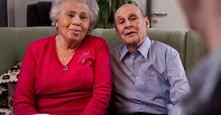 Älteres Paar auf ihrem Sofa in ihrer Service-Wohnung