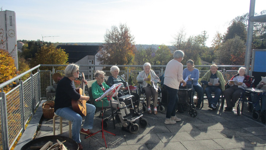 Auf der Terasse genießen Bewohner*innen der ProCurand Seniorenwohnanlage Fideliswiesen die Herbstsonne