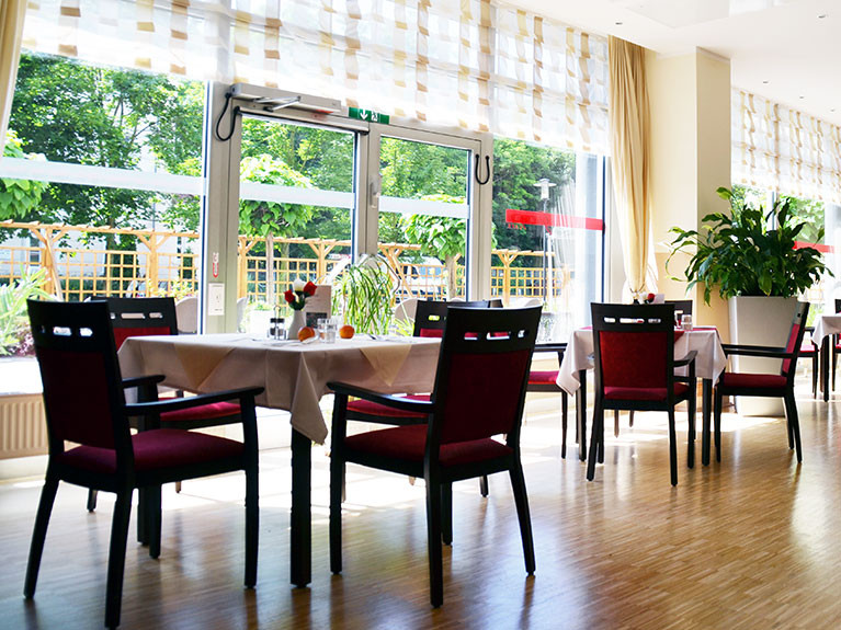 Große Fenster schaffen eine offene Atmosphäre und bringen viel Licht in das Café der Seniorenresidenz