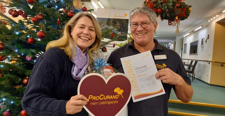 Einrichtungsleitung Janin Tiedemann überreicht Jörg Pasch eine Urkunde sowie weitere Prämien für 30 Jahre in der ProCurand Seniorenresidenz Am Strausssee.
