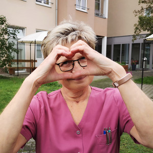 ProCurand Seniorenresidenz Senftenberg Wohnbereichsleitung im Garten der Senioreneinrichtung macht Herzhände