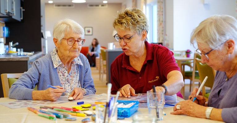 Seniorinnen und Mitarbeiterin bei der Beschäftigung