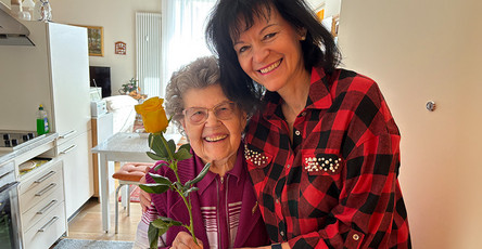 Pflegedienstleitung Andrea Liebner übergibt Seniorin der  Seniorenresidenz Bölschestraße eine gelbe Rose zum Weltfrauentag.