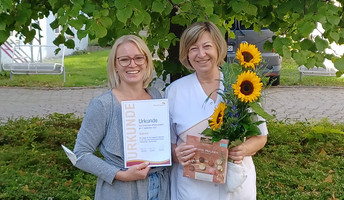 Einrichtungsleitung Laura Hewel gratuliert Sabine Schlappe zu ihrem Jubiläum in der ProCurand Seniorenwohnanlage Fideliswiesen.