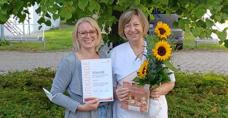 Einrichtungsleitung Laura Hewel gratuliert Sabine Schlappe zu ihrem Jubiläum in der ProCurand Seniorenwohnanlage Fideliswiesen.