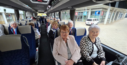 Im Bus sitzt die fröhliche Reisegruppe aus der ProCurand Residenz Am Hallorenring, die sich auf den gemeinsamen Ausflug nach Berlin freut.
