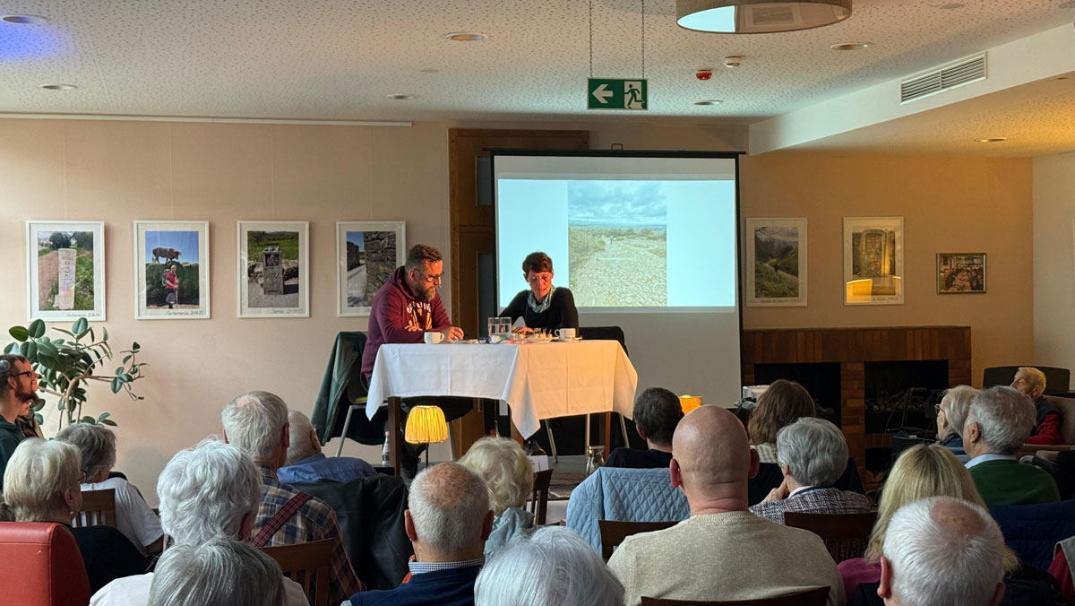 Im Restaurant Vier Jahreszeiten der ProCurand Seniorenresidenz Bölschestraße lauschen Bewohner*innen der Lesung und Präsentation von Denise und Sebastian Grytzka über ihre Pilgerreise auf dem Jakobsweg.