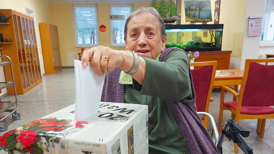 Eine Seniorin wählt ihre Favoriten bei der Bewohnerschaftsratswahl in der ProCurand Seniorenresidenz Am Görnsee.