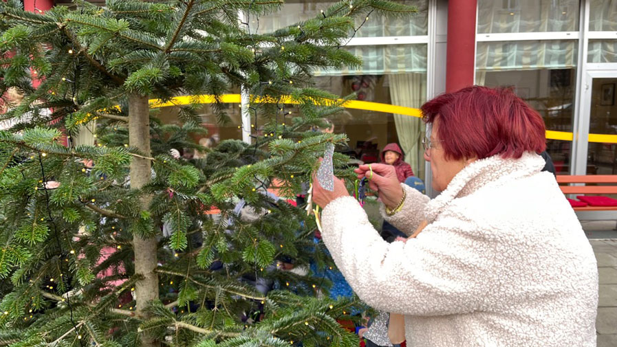 Eine Seniorin der ProCurand Seniorenresidenz Am Krökentor schmückt den Weihnachtsbaum.