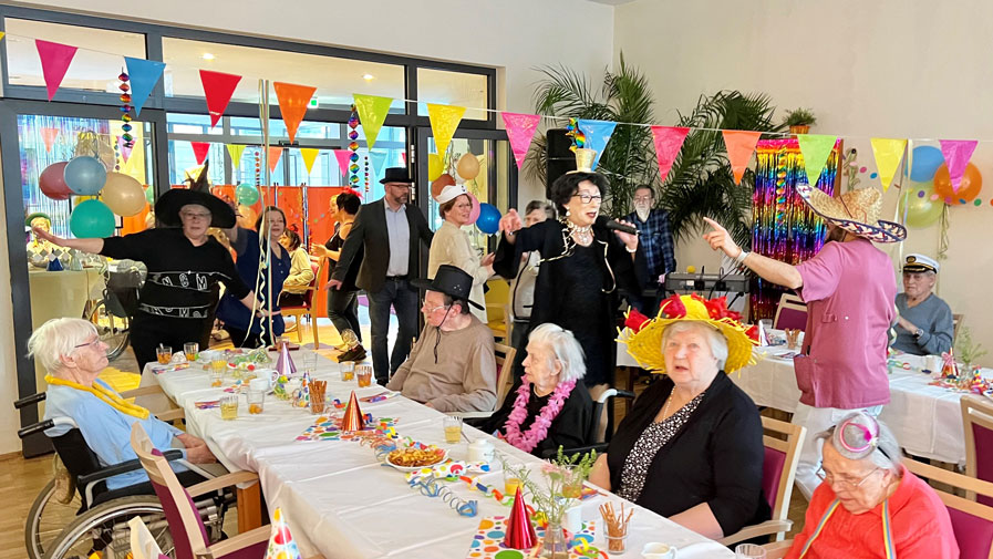 Die Senior*innen und Mitarbeiter*innen der ProCurand Seniorenresidenz Park Sanssouci haben viel Spaß bei der Faschingsparty.