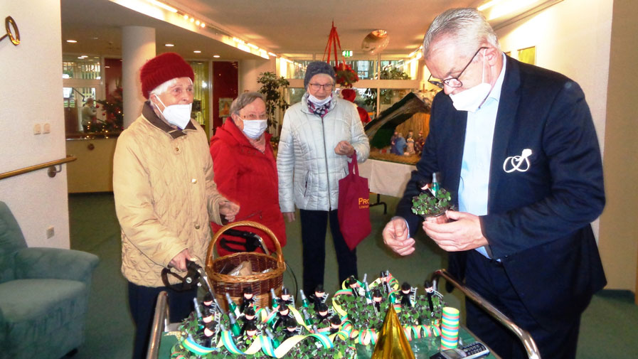 Einrichtungsleiter Thomas Korbjuhn verteilt Silvesterüberraschung in der Seniorenresidenz Am Straussee