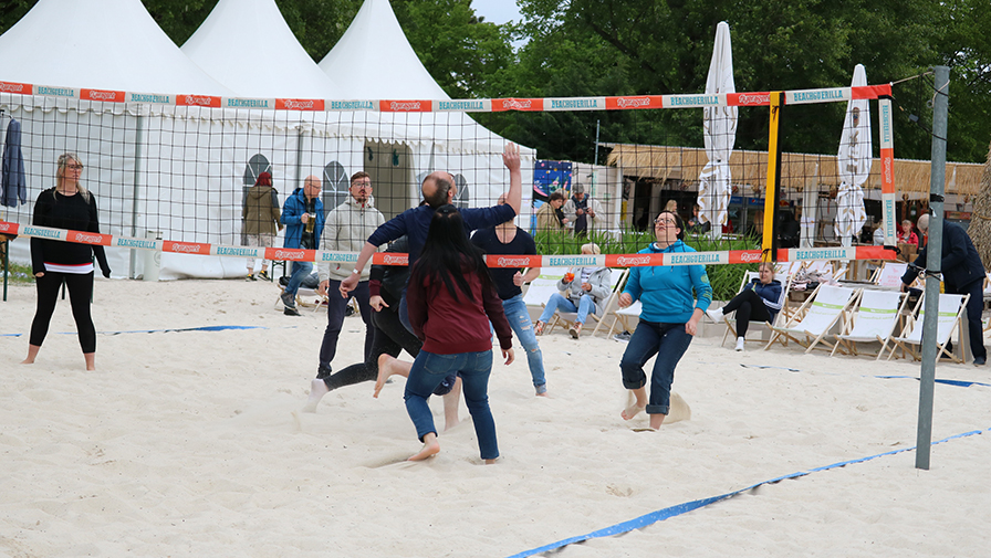 Magdeburger Mitarbeiter*innen spielen Beachvolleyball in Strandbar