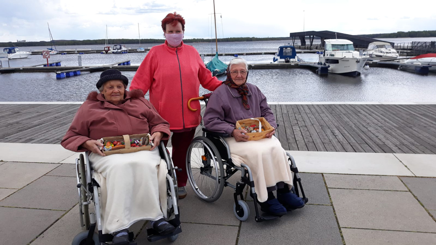 Zwei Seniorinnen bringen selbst bemalte Steine zur Seeschlange