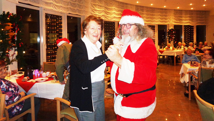 Tanz mit dem Weihnachtsmann im Bereich Service-Wohnen der ProCurand Seniorenresidenz Am Straussee.