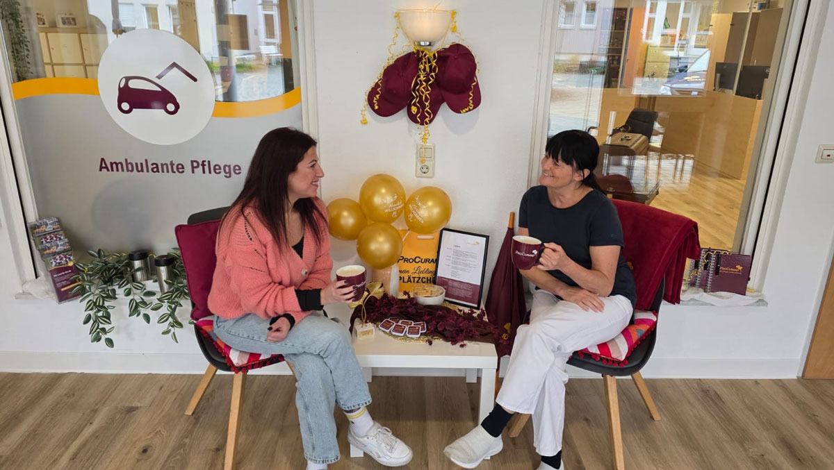Im Empfangsbereich der ProCurand Ambulanten Pflege Sigmaringen informiert das Leitungsteam Besucher*innen an einem dekorierten Tisch.