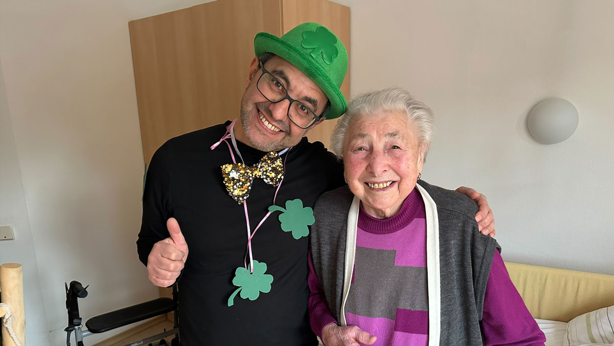 Neujahrsgruß im ProCurand Pflegestift Pfarrer Lukas in Cham: Bewohnerin mit Glücksboten Kleeblatt beim Rundgang durchs Haus.