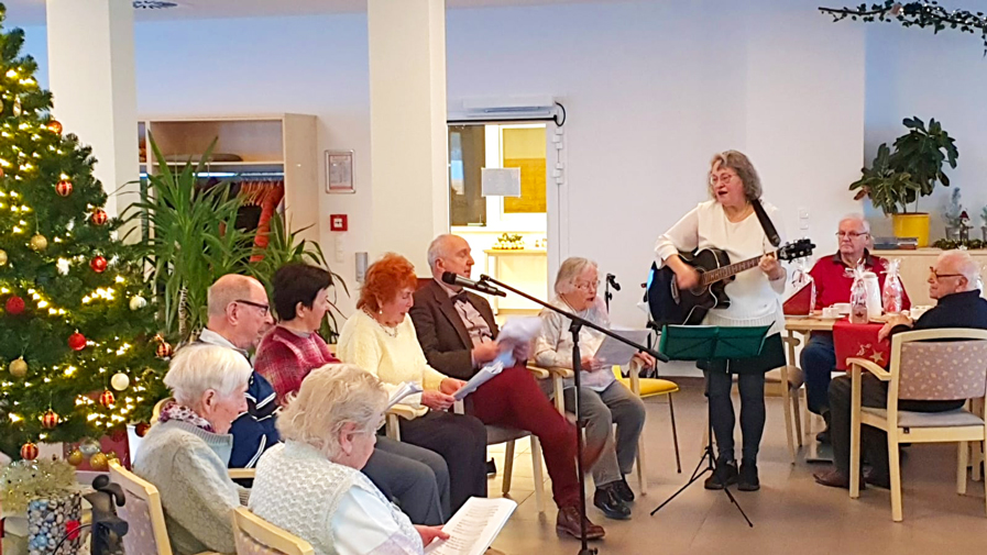 Die Mieter*innen singen gemeinsam Weihnachtslieder bei der Weihnachtsfeier in der ProCurand Strausberg Wriezener Straße. 