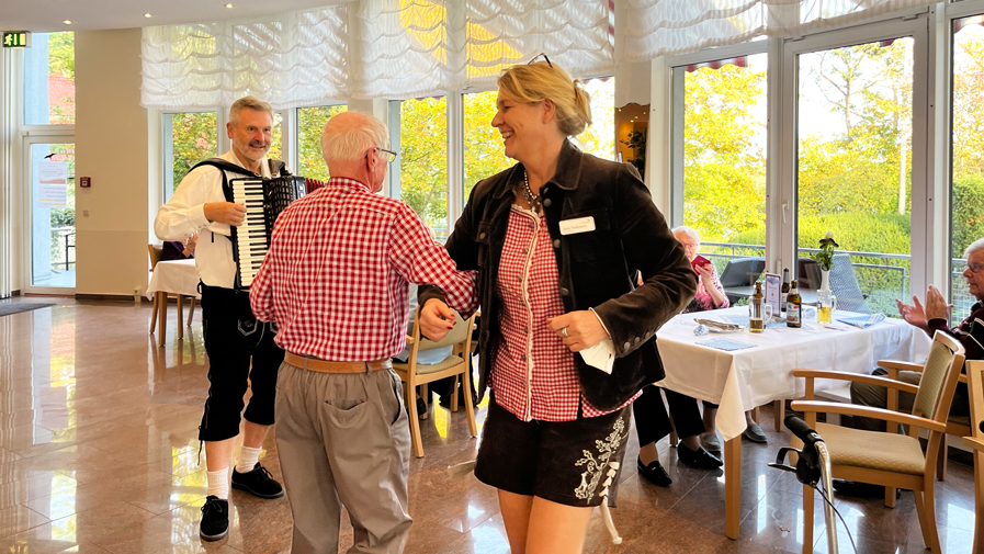 Einrichtungsleitung Janin Tiedemann tanztmit einem Bewohner der ProCurand Seniorenresidenz Am Strausssee