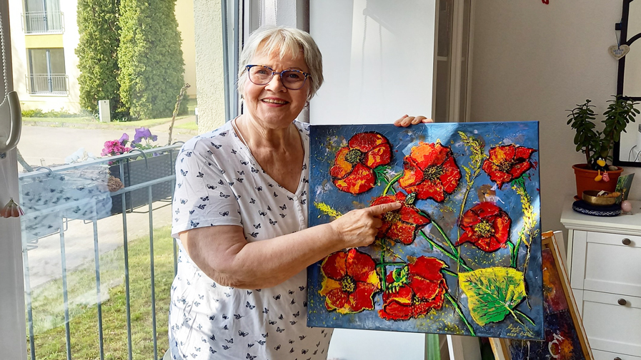 Die Künsterin, eine Bewohnerin der ProCurand Strausberg mit einem ihrer Gemälde
