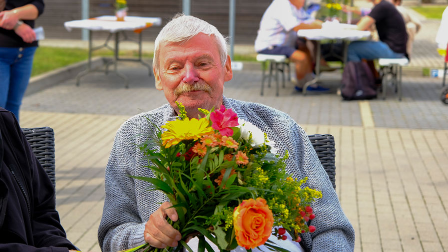 Mitglied des Mieterbeirates der Wriezener Straße mit Blumenstrauß