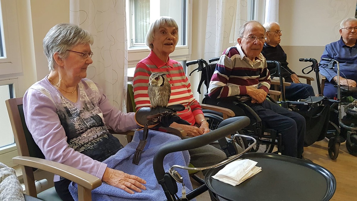 Seniorin mit einer Eule auf dem Arm in der Seniorenresidenz Bölschestraße