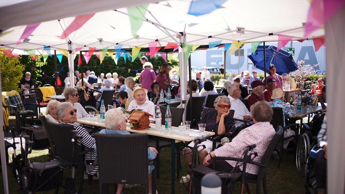 Senior*innen sitzen zusammen auf der Terrasse der Seniorenresidenz Bölschestraße