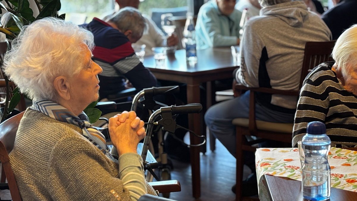 Bewohner*innen sitzen im Restaurant Vier Jahreszeiten und verfolgen aufmerksam das Konzert. Die ruhige, konzentrierte Atmosph&auml;re zeigt, wie sehr die Musik ber&uuml;hrt und zum Innehalten einl&auml;dt.