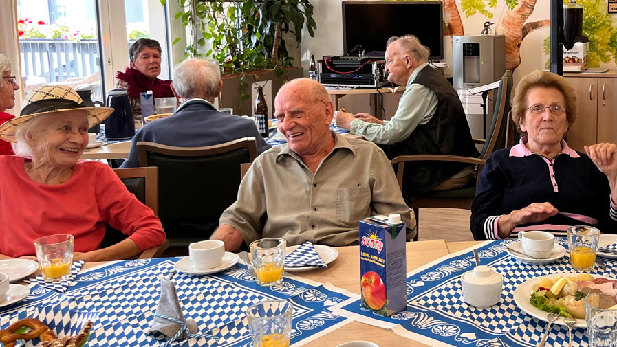 Am Tisch wird viel gelacht und gemeinsam geschlemmt – die Bewohner*innen der ProCurand Seniorenresidenz Bölschestraße genießen das Oktoberfest in vollen Zügen!