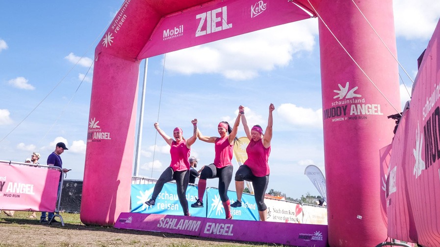 Carers from the Am Schlosspark senior citizens' residence jump hand in hand over obstacles at the Muddy Run