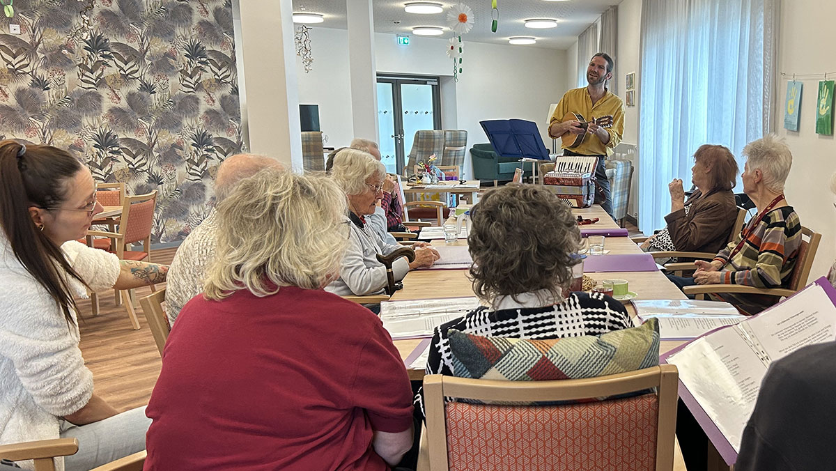 Senior*innen und Musiker Johannes Oster beim gemeinsamen Musizieren in der Tagespflege Eberswalde
