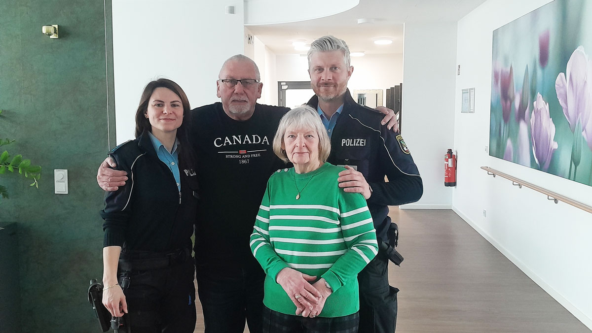 Zwei Polizeibeamte und Teilnehmerinnen der Tagespflege stehen gemeinsam f&uuml;r ein Foto zusammen und zeigen die gelungene Informationsveranstaltung in freundlicher Atmosph&auml;re.