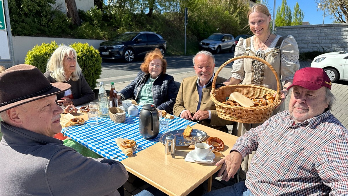 Bewohner*innen und Kolleg*innen sitzen gemeinsam am Tisch